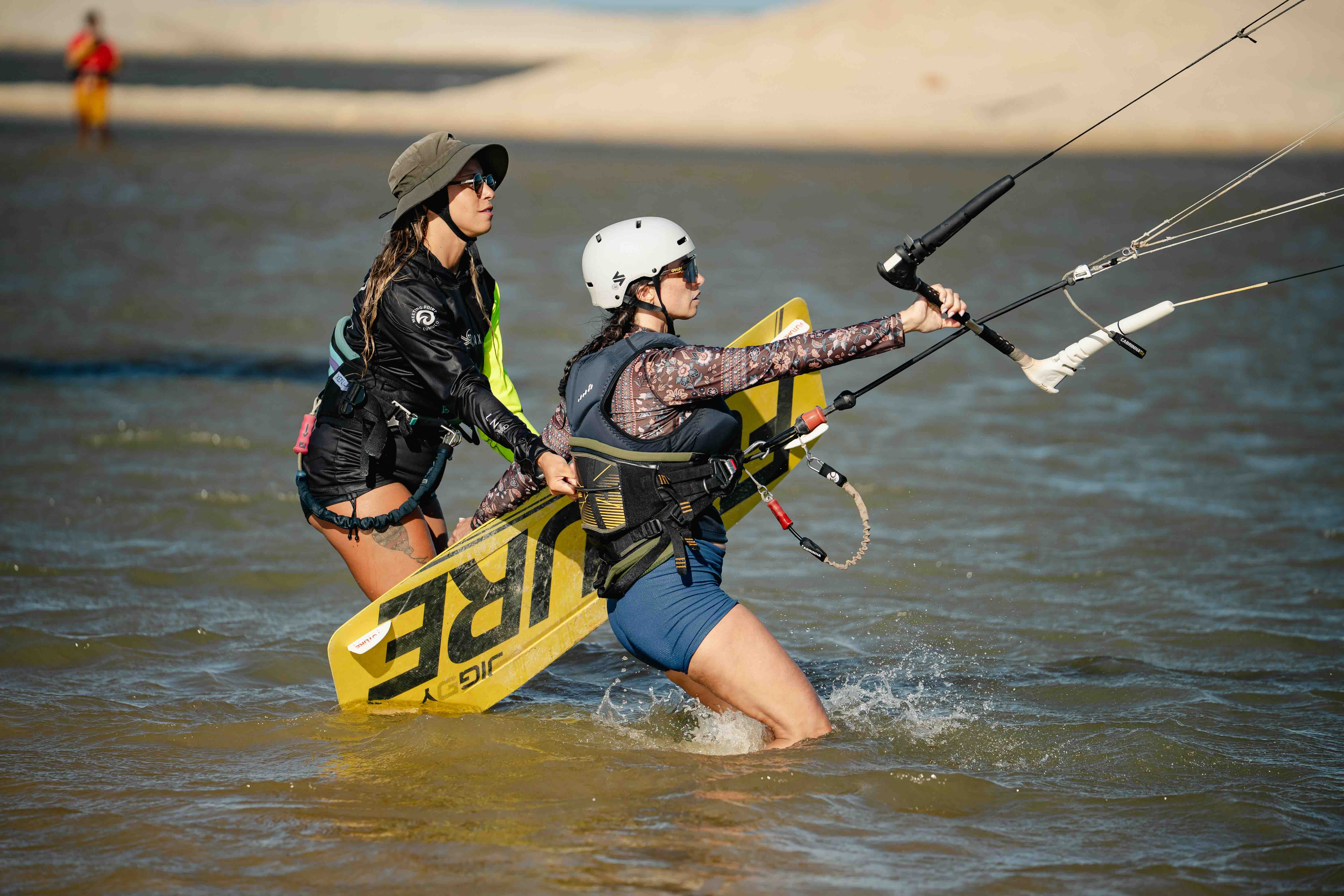 Women preparing kite equipment in the lagoon